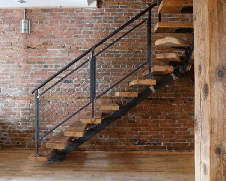 29. Escada flutuante de madeira com estrutura metálica complementa a decoração industrial. Fonte: Houzz