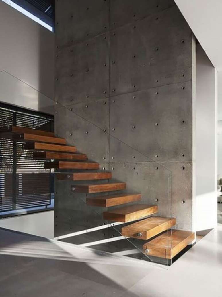 75. Escada com degraus flutuantes de madeira fixada em parede de cimento. Fonte: pinterest