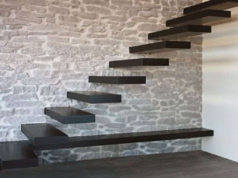 76. Escada com degraus flutuantes de madeira fixada em parede de pedras. Fonte: Pinterest