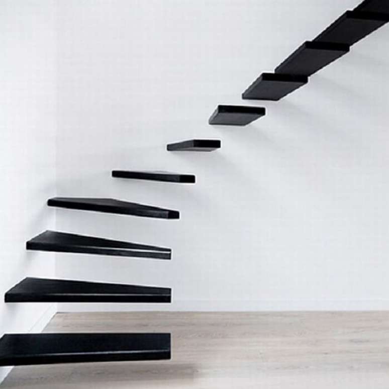 38. Escada flutuante de madeira preta fixada a uma parede branca. Fonte: Homedit