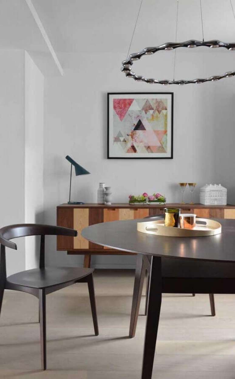 12. Decoração clean para sala de jantar com buffet de madeira, mesa redonda e quadro tumblr – Foto: Zozu