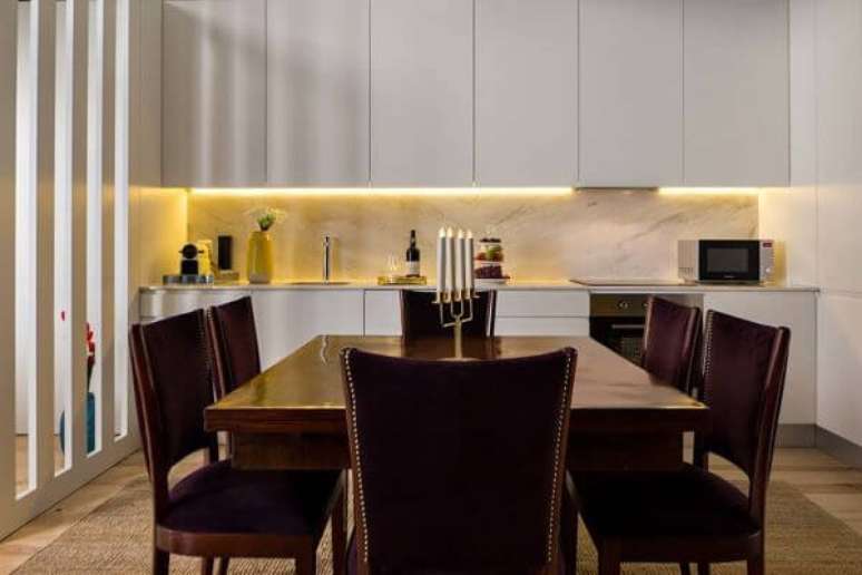 67. Modelos de cozinha com armários de parede em porcelanato claro e cadeira da mesa de jantar em veludo.