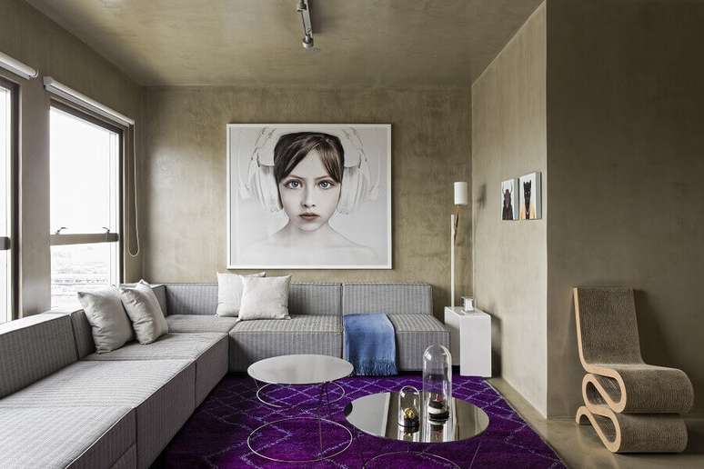 39. Decoração moderna para sala com parede de cimento queimado, sofá de canto e grande quadro tumblr – Foto: Archello
