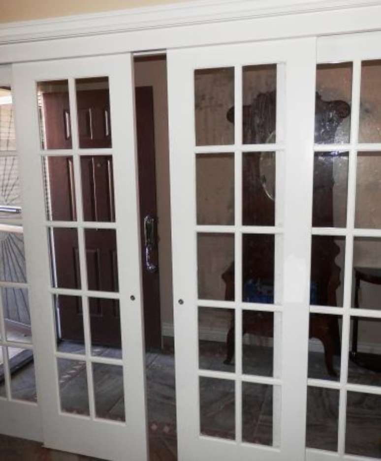 27. A porta balc&atilde;o branca &eacute; o que h&aacute; de mais popular. Foto: Ecoville Portas e Janelas