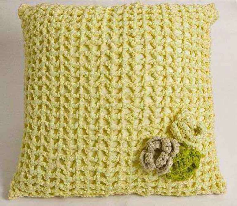 24- Almofada de crochê amarela tem aplicação de flor. Fonte: Construideia