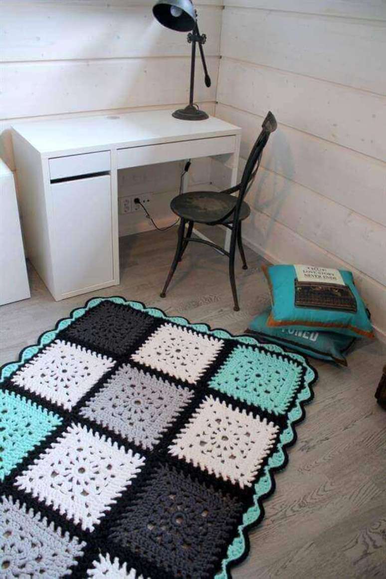 27- O tapete de crochê é feito com quadrados coloridos unidos por pontos com lã preta. Fonte: Cherrymarja