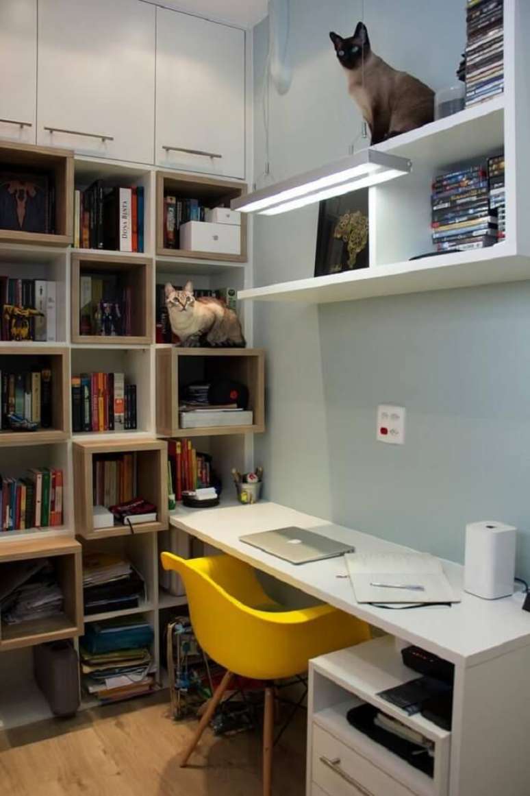 32. Estante de nichos, mesa branca e cadeira para escritório do tipo Eiffel amarela. Projeto por Ana Lúcia Adriano