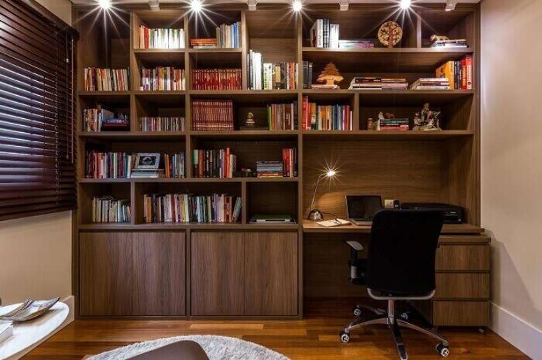 41. Home office e biblioteca integrados contam com a presença de uma cadeira para escritório presidente. Projeto por BY Arq & Amp Design