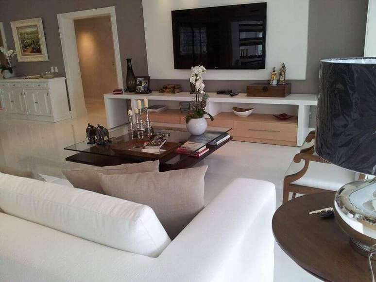 40. Painel com rack branco para sala ampla decorada com mesa de centro quadrada de vidro &ndash; Foto: Lucio Nocito