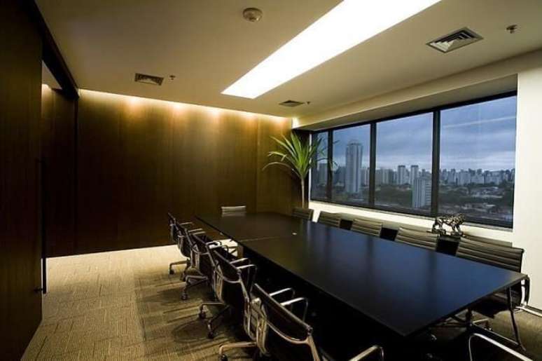 49. Sala de reunião formada com com cadeira para escritório na cor preta. Projeto por Mauricio Karam