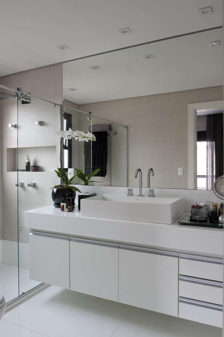 42. Os banheiros planejados podem contar com espelho até o teto para ampliar visualmente o espaço. Projeto por Jamile Lima