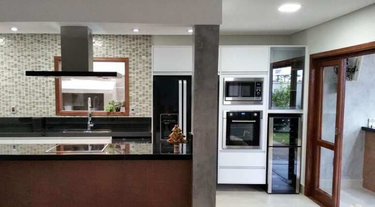 14. Cozinha americana com geladeira preta. Projeto por Clara Sacco