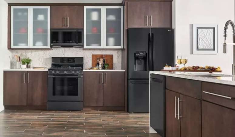 2. Cozinha ampla com geladeira preta duas portas. Fonte: Reviewed