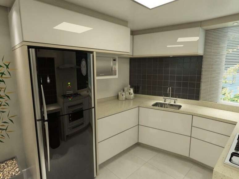 21. Cozinha em formato l com geladeira preta embutida. Projeto por Ednilson Hinckel