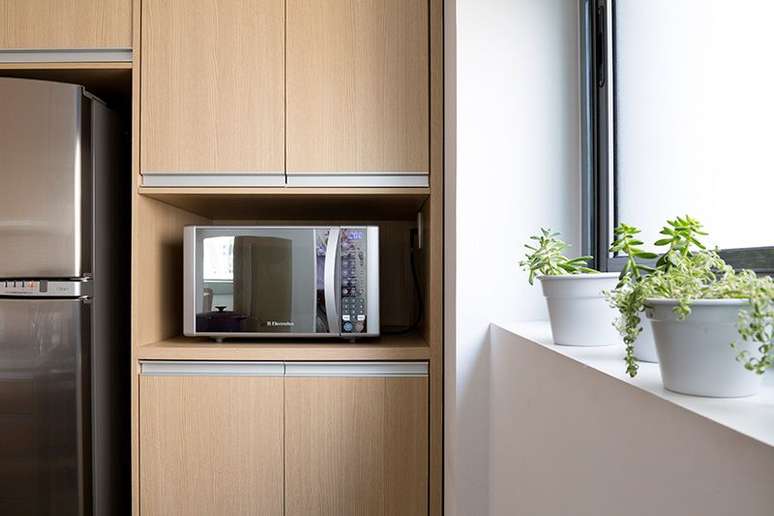 38. O micro-ondas espelhado combina muito com uma geladeira de inox. Projeto de Juliana Conforto