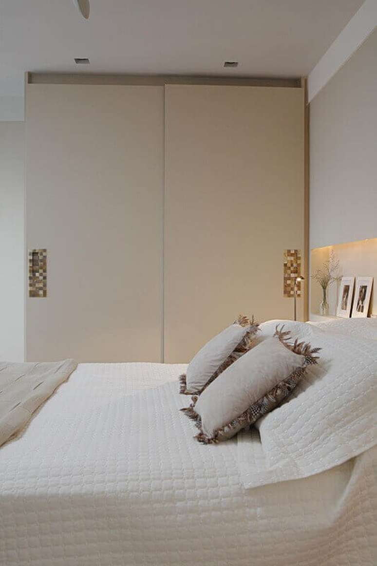 3. Guarda-roupa planejado com portas discretas que otimizam o espa&ccedil;o e puxadores personalizados. Projeto de Karen Pisaca