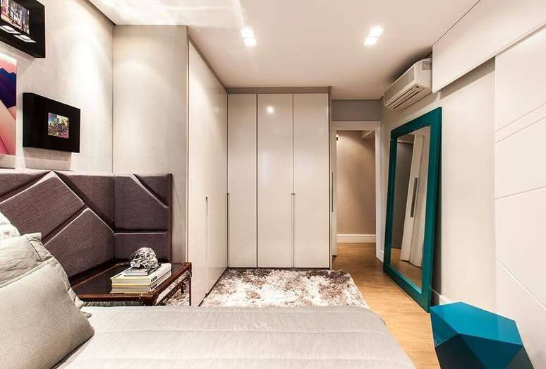 25. Neste projeto de B&aacute;rbara Dundes, o guarda-roupa planejado grande forma um ambiente perfeito para prova de roupas na frente do espelho