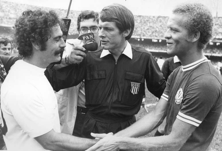  Os jogadores Roberto Rivelino (e), do Corinthians e Ademir da Guia (d), do Palmeiras, se cumprimentam sendo observado pelo juiz Dulcídio Wanderley Boschilla, antes da partida válida pela final do Campeonato Paulista de Futebol de 1974 no estádio do Morumbi, zona sul da cidade de São Paulo.