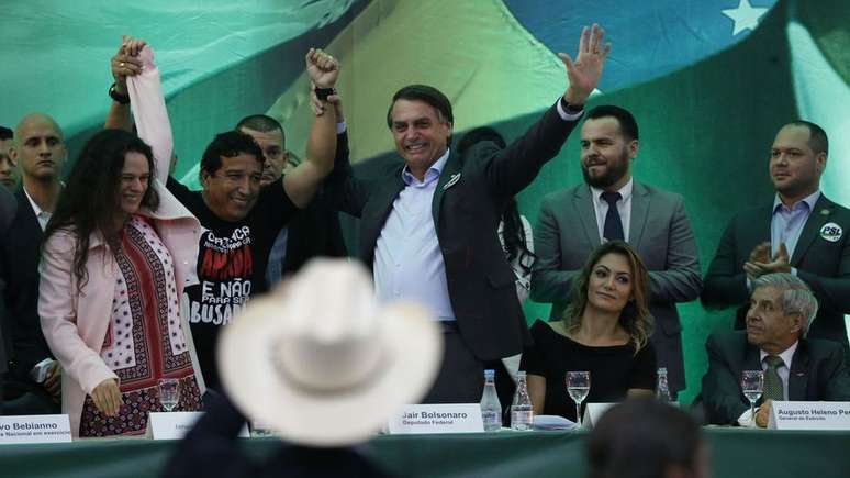 Em pé, Paschoal e Bolsonaro aparecem sorrindo durante evento que oficializou o nome dele na eleição de 2018, da qual saiu vencedor