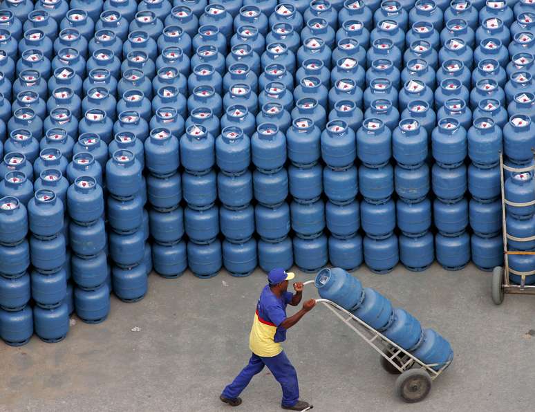 Trabalhador transporta botijões de gás de cozinha nas instalações de uma distribuidora em São Paulo 