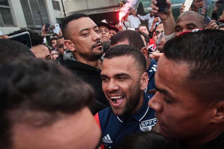 Daniel Alves é recebido em aeroporto com festa pela torcida do São Paulo.