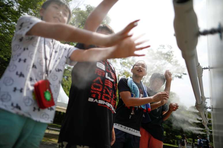 Crianças se refrescam em névoa durante testes de medidas para combater o calor antes dos Jogos Olímpicos de Tóquio 2020, em Tóquio, no Japão
25/07/2019
REUTERS/Issei Kato