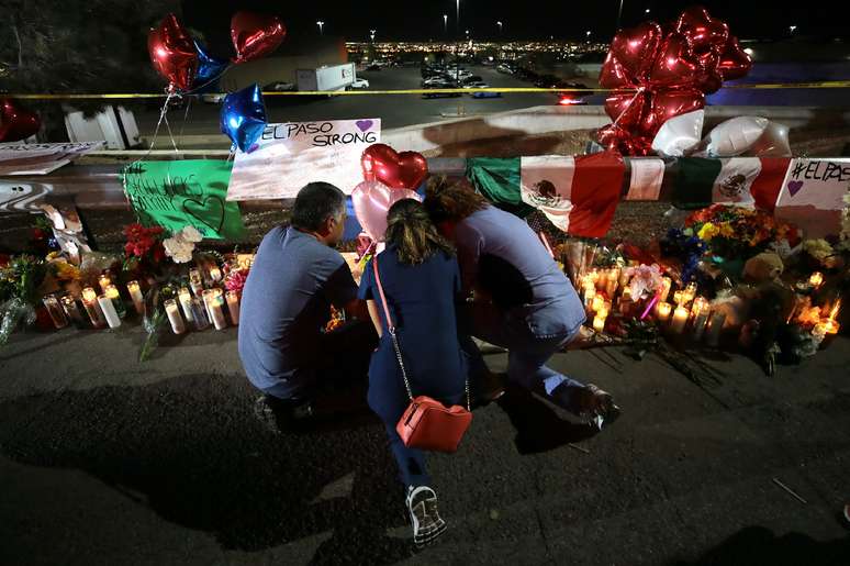 Pessoas rezam e colocam objetos em frente ao Walmart em El Paso, palco do massacre