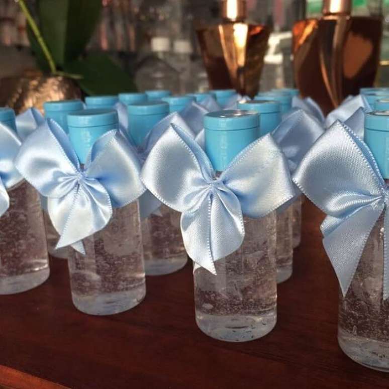 36. Frasco com &aacute;lcool em gel e la&ccedil;o azul utilizado como lembrancinha de maternidade. Fonte: Mari Ven&acirc;ncio