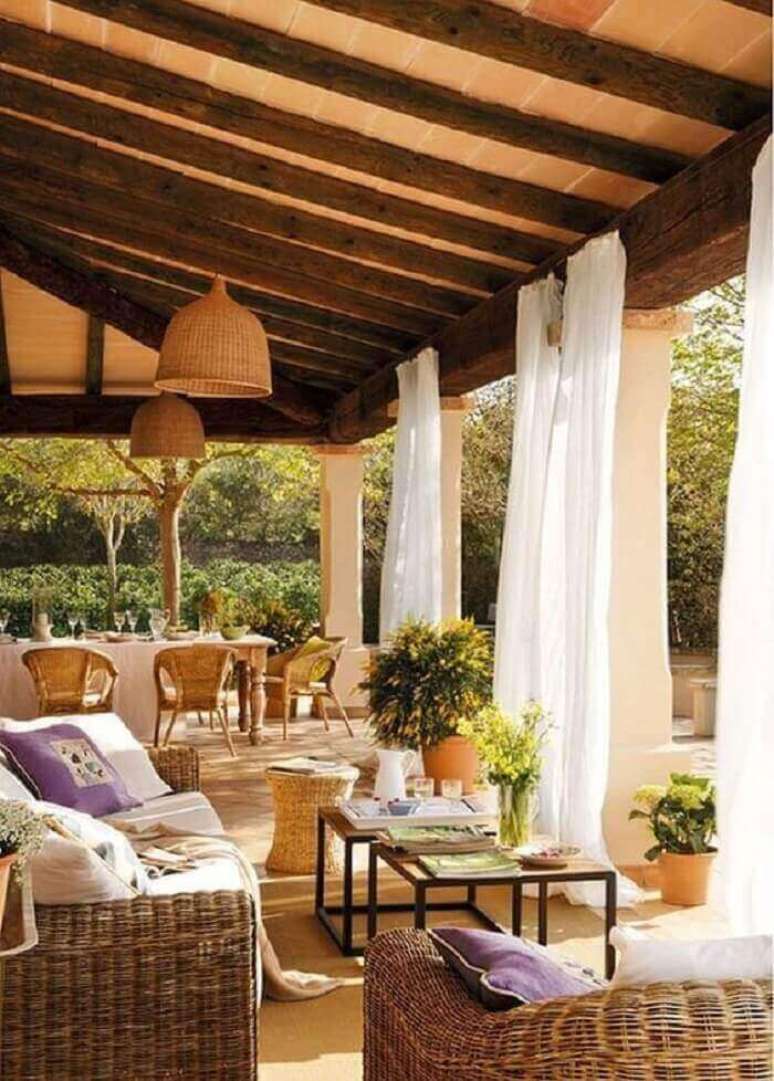 33. As cortinas brancas minimizam a entrada de luz solar na varanda de madeira. Fonte: Pinterest