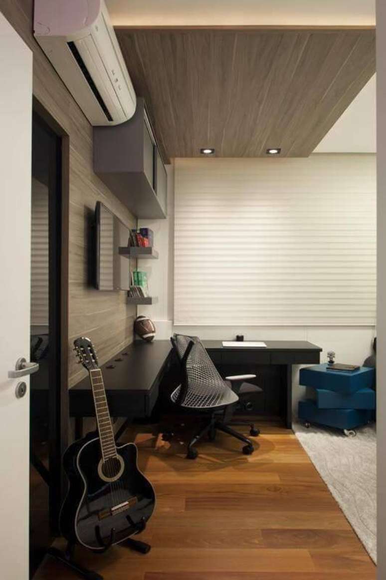 23. O quarto de solteiro moderno ganha o calor do chão com carpete de madeira. Projeto por Sartori Design.