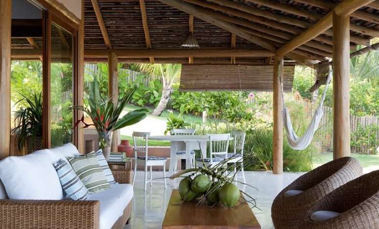 35. Casa de praia com varanda de madeira, móveis rústicos e rede para descanso. Fonte: Tecto