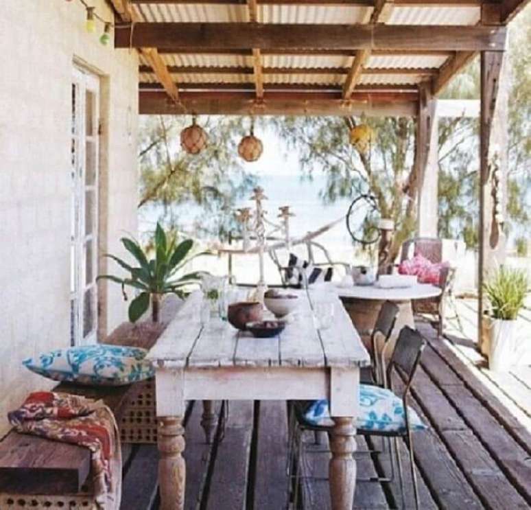 15. Casa de veraneio com varanda de madeira e móveis rústicos. Fonte: Haus Decoração