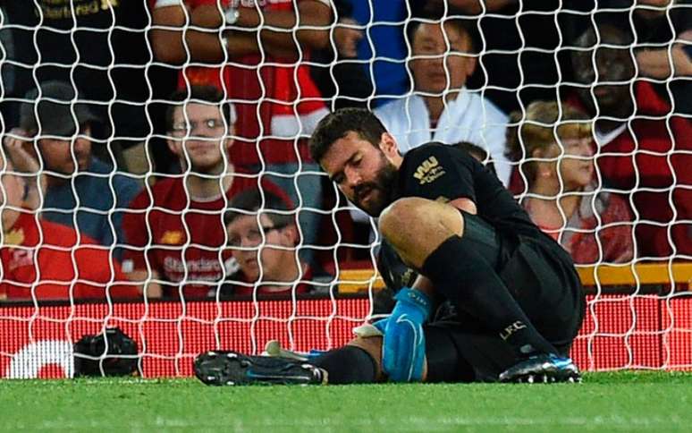 Alisson caiu ao chão após cobrar tiro de meta (Foto: OLI SCARFF / AFP)