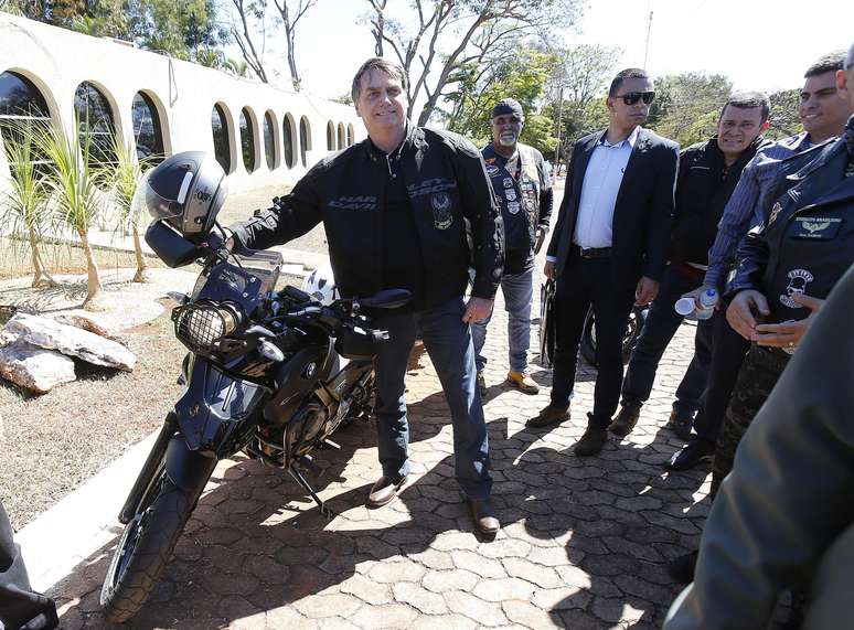 O presidente da República, Jair Bolsonaro (PSL), ao lado de uma moto BMW 1200, no Clube da Aeronáutica, em Brasília, após passear com a motocicleta, neste domingo (11)