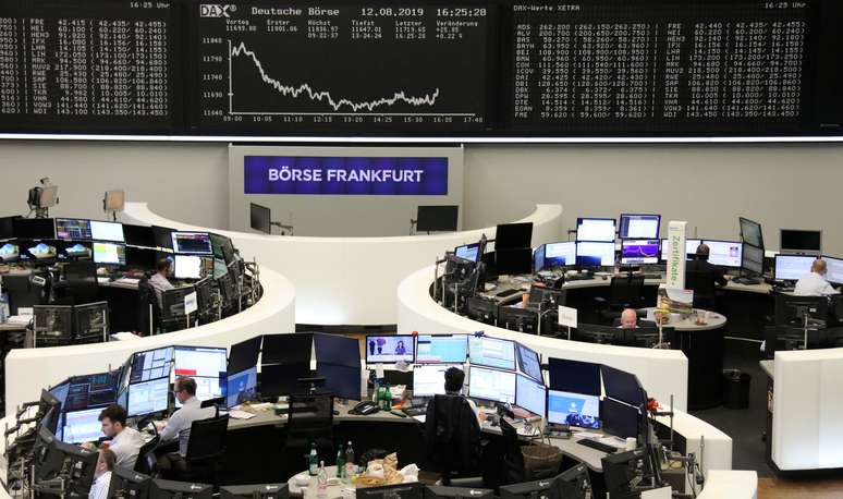Funcion&aacute;rios da bolsa de valores alem&atilde; trabalham durante preg&atilde;o, com o painel ao fundo mostrando o comportamento do &iacute;ndice DAX. 12/8/2019.    REUTERS/Staff 