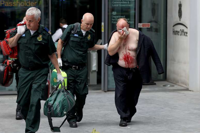 Homem ferido &eacute; ajudado por m&eacute;dico do lado de fora do Minist&eacute;rio do Interior do Reino Unido, em Londres
15/08/2019 REUTERS/Simon Dawson