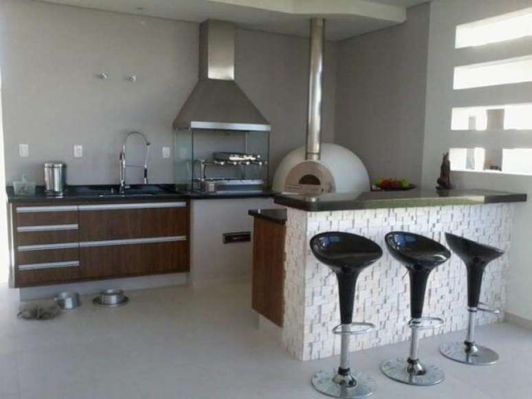 15. &Aacute;rea de lazer pequena com churrasqueira de vidro com coifa e forno de pizza. Fonte: Rachel Avellar