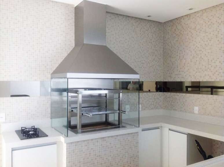 51. Churrasqueira de vidro com coifa de inox instalada ao lado do cooktop. Fonte: Pinterest