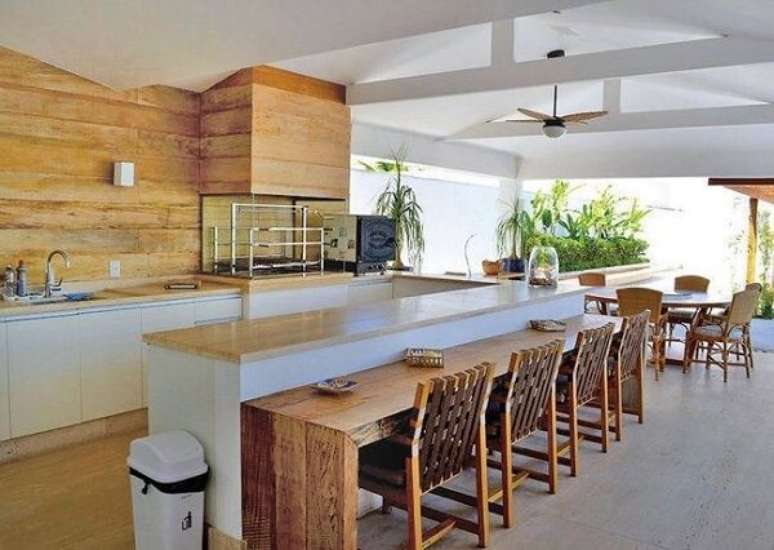 39. Espa&ccedil;o gourmet para reunir fam&iacute;lia e amigos com churrasqueira de vidro e bancada de madeira extensa. Fonte: Casa e Festa