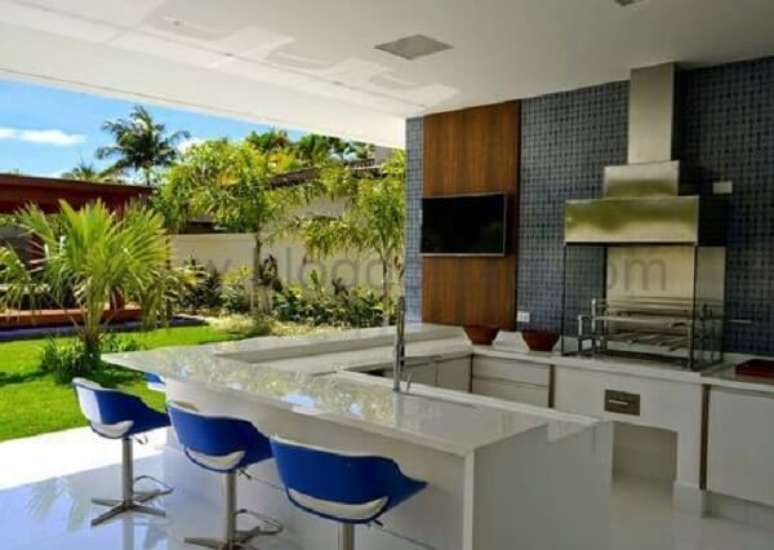 22. Varanda gourmet integrada ao jardim com churrasqueira de vidro e inox. Fonte: Dicas de Decora&ccedil;&atilde;o