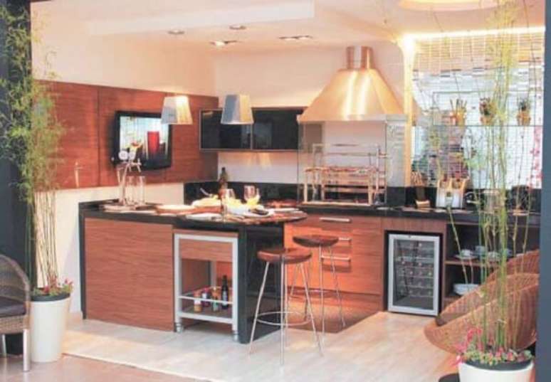 47. &Aacute;rea de lazer pequena com pendentes met&aacute;licos, banquetas, adega embutida e churrasqueira de vidro. Fonte: Zap M&oacute;veis