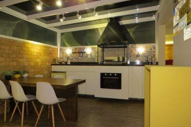 29. Varanda gourmet com ampla bancada e churrasqueira de vidro com coifa e forno embutido. Fonte: Paula Oliveira Szabo