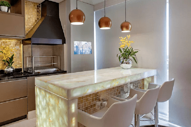 61. Varanda gourmet com bancada de m&aacute;rmore iluminada e churrasqueira de vidro. Fonte: Pinterest