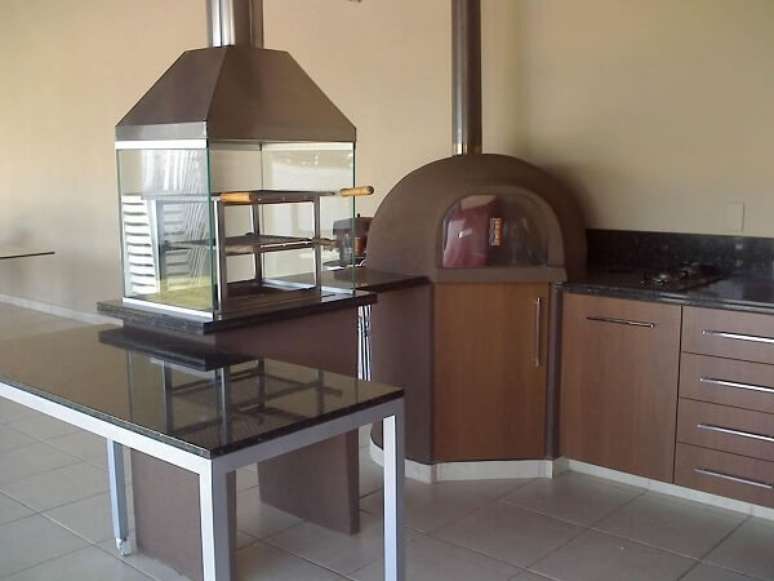 31. Varanda gourmet com churrasqueira de vidro e bancada em l. Projeto por &Eacute;rika Godoi