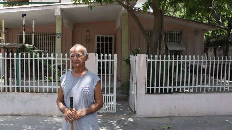 Gerardo Serra, como muitos outros vizinhos de Guanta, varre a frente de sua casa diariamente para evitar o acúmulo de poeira de cimento