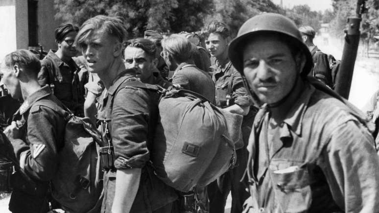 Prisioneiros alemães sendo vigiados por um dos muitos soldados argelinos que lutaram no sul da França