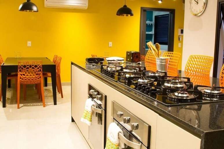 29. Bancada para cozinha com cooktop e paredes amarelas – Foto: Abreu Coimbra Arquitetura
