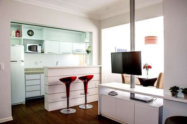 34. Bancada para cozinha americana pequena toda branca com banquetas vermelhas &ndash; Foto: Elisangela Cardoso