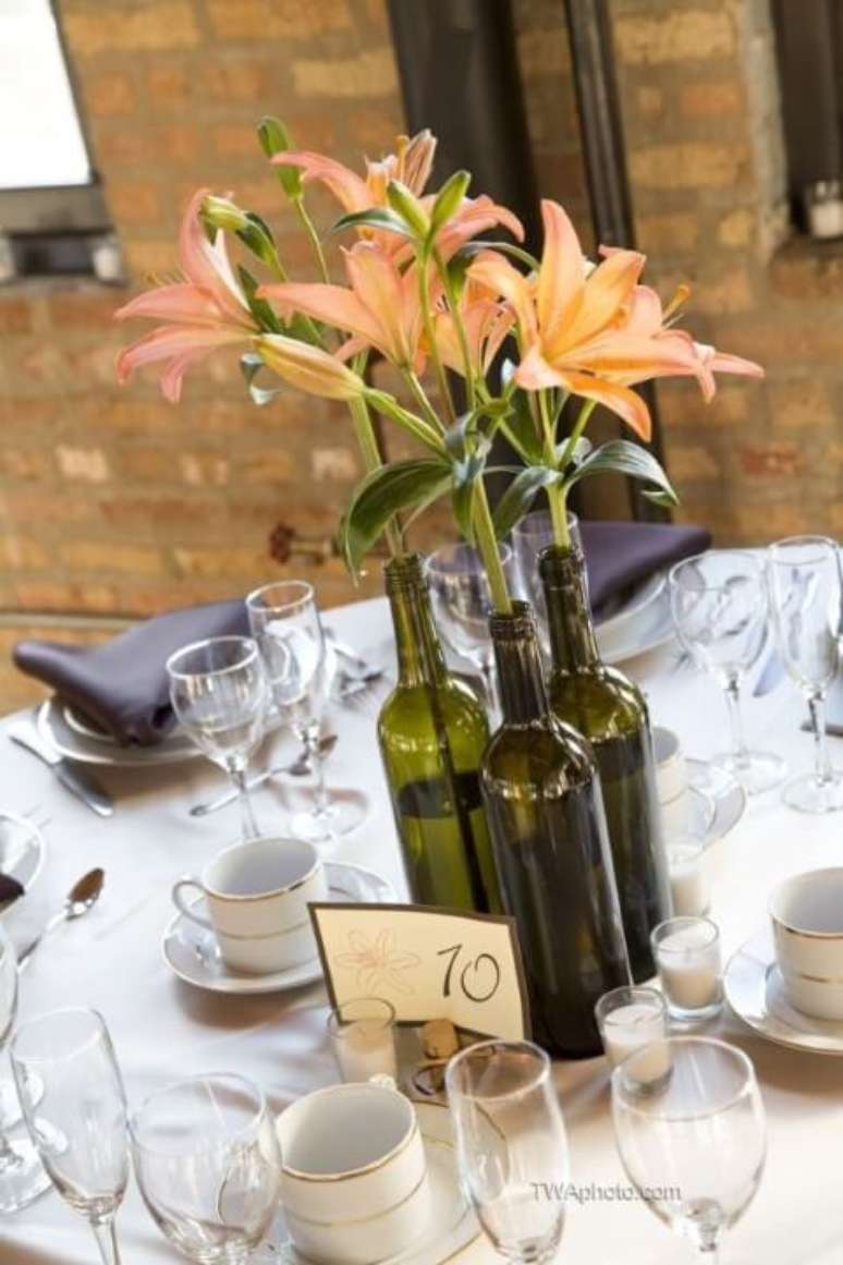 12. Garrafas de vinho com flores como centro de mesa