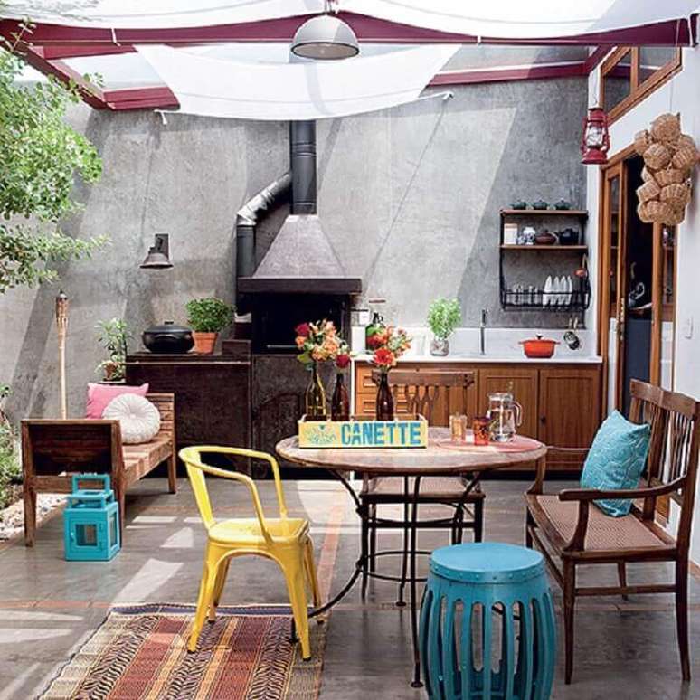 24. Área externa decorada com móveis de madeira e garden seat azul – Foto: Nô às Nove